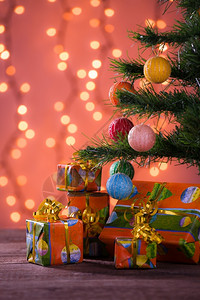 树下木板上背景灯光模糊的圣诞礼物灯光模糊的圣诞礼物莫比代利室内的闪亮图片