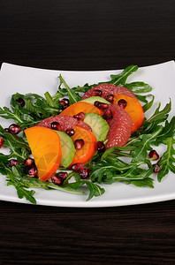 健康柿子沙拉加伏卡多葡萄果百西蒙石榴和青铜茶点图片