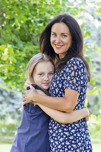 二十欧洲的淑女夏月以绿色背景为母亲和女儿拥抱绿色背景图片