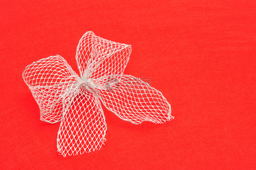 红色背景上孤立的银色蝴蝶结装饰圣诞节生日图片