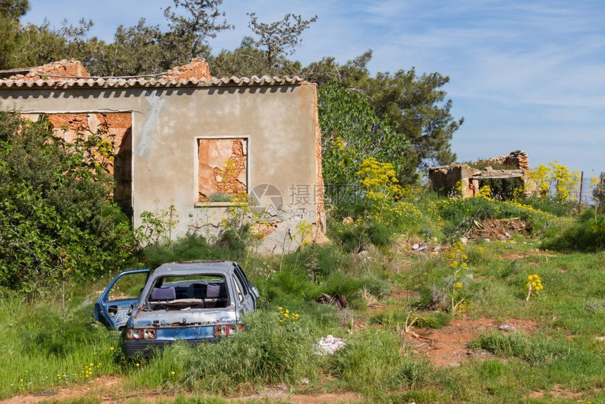 天空绿色地中海塞浦路斯岛Diorios村废弃房屋和汽车的残废住房和辆景观图片