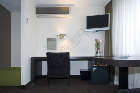 一个小型但奢华和现代的旅馆房间装有各种电器和特质征一种窗帘图片
