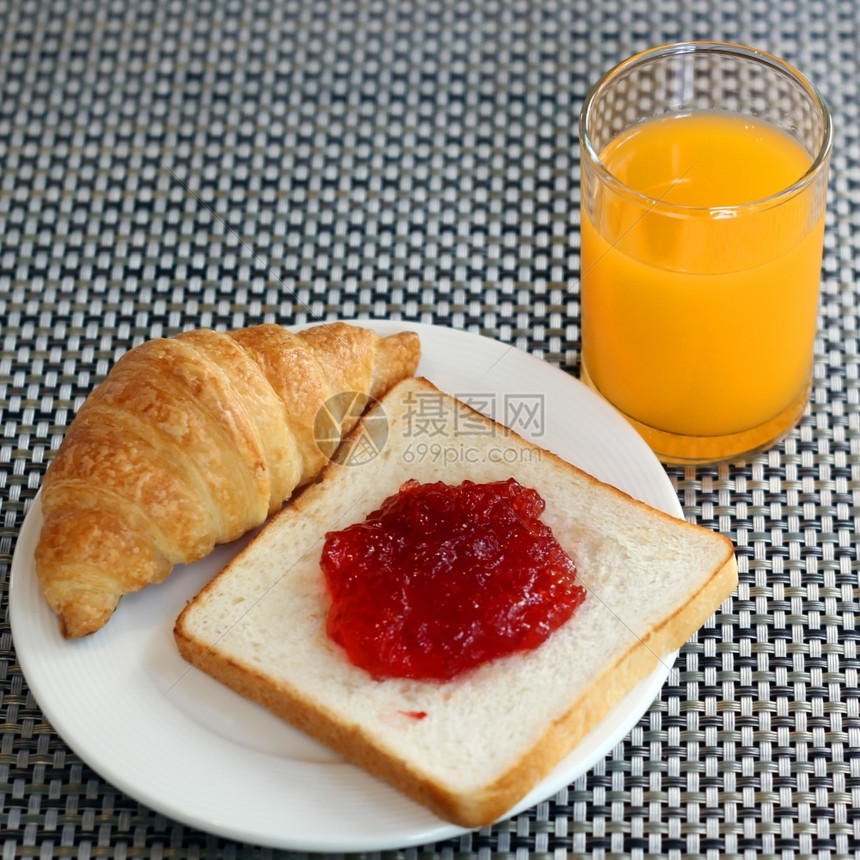 香脆的早晨午餐面包羊角和橙汁上的草莓果酱图片