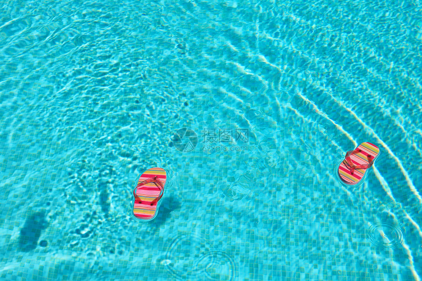 泳池中漂浮的彩色拖鞋图片