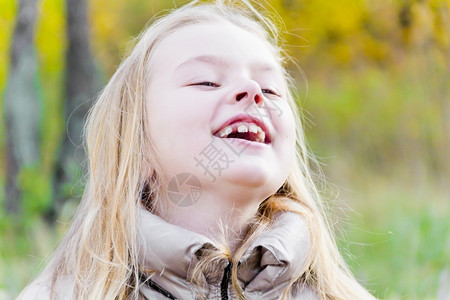 阳光下欢笑女孩的秋天肖像图片