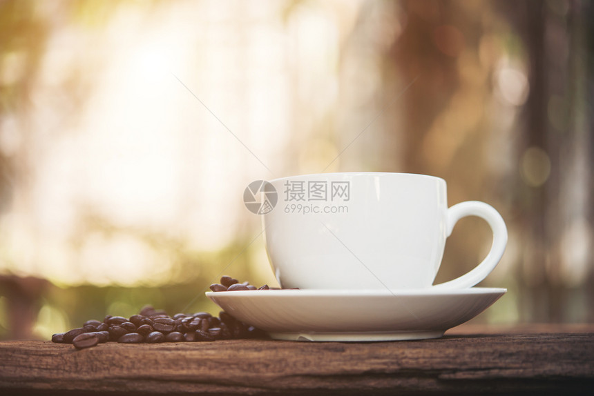 木桌上咖啡杯和咖啡豆图片