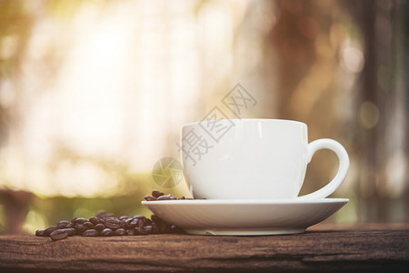 木桌上咖啡杯和咖啡豆图片