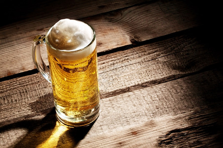一种酒精透明杯子木制桌上有轻啤酒水壶图片