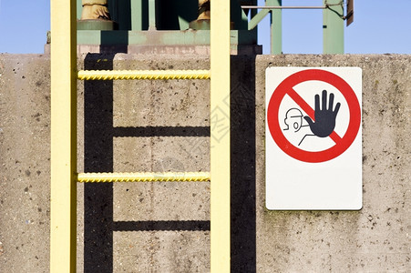 肮脏的工业在一个厂混凝石柱上一个梯子和没有进入警告信号标志结构体图片