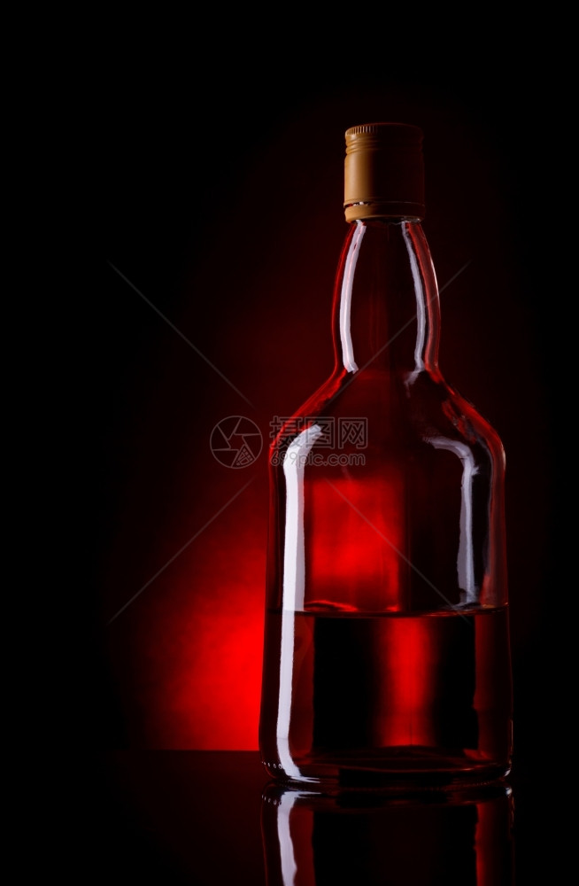 照片小插图深红色背景的威士忌瓶装液体图片
