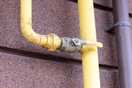 一个黄色气管有水龙头在房子外面的一栋来把家里的软能量融化墙管道活力图片