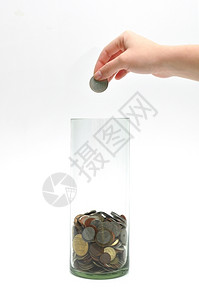 金融基投资妇女用手把硬币扔进玻璃罐图片