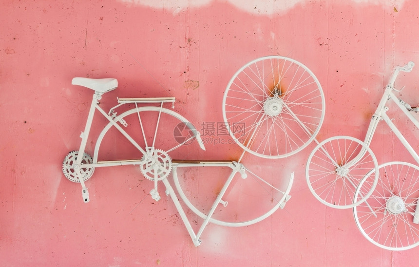 木板颜色目的自行车一部分挂在粉红色墙壁背景上图片