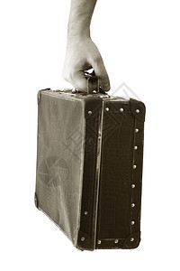 挂起色调风化手拿着一个旧提箱的Sepia刻面相片短距离深处锋利在手背景图片