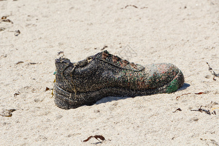 布列塔尼海滩沙上的旧鞋污染垢塑料肮脏的图片