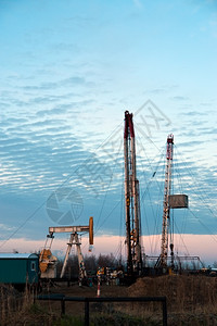 机器行业俄罗斯西伯利亚州俄罗斯日落天空背景的石油泵和钻井机孔图片