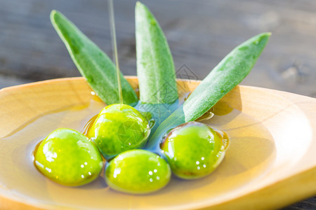 地中海汤匙里的橄榄超过额外的处女橄榄油提示黄色的图片