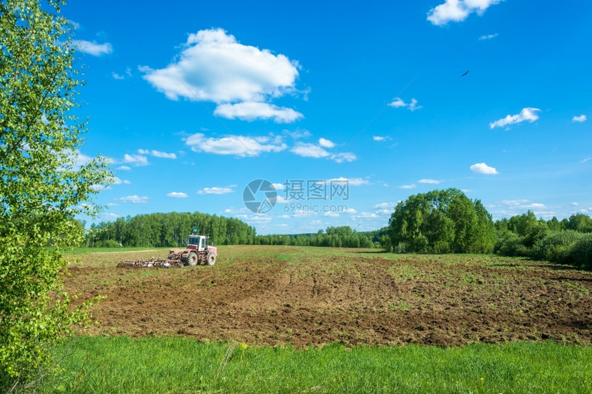Sunny夏季日在田里工作的轮式拖拉机春天农场械图片