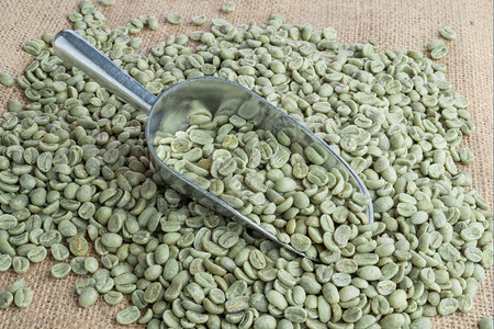 金属勺中的绿咖啡豆图片