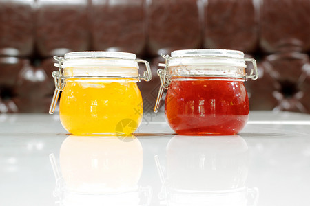 在白桌上的罐子里做自制草莓和菠萝果酱橙健康一顿饭图片