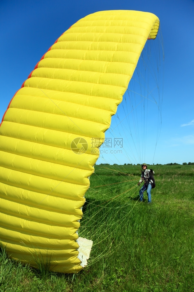 蓝色的天空青年男子伞式飞机驾驶员操作降落伞图片
