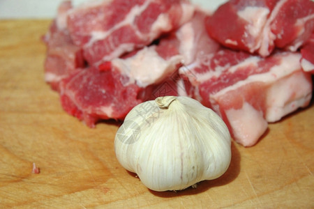营养厨房桌上铺着新鲜肉和大蒜猪室内的图片
