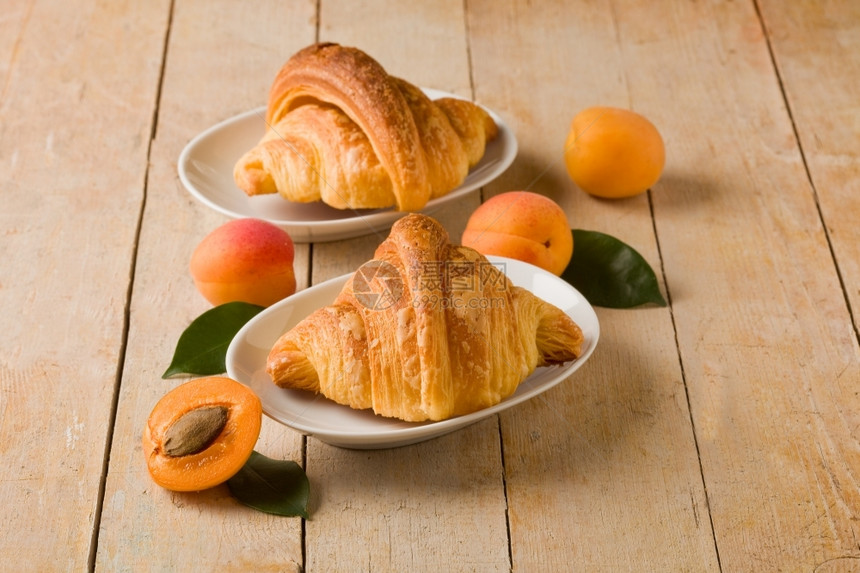 健康早餐填充照片美味的金羊角面包木制桌上有杏仁果酱图片