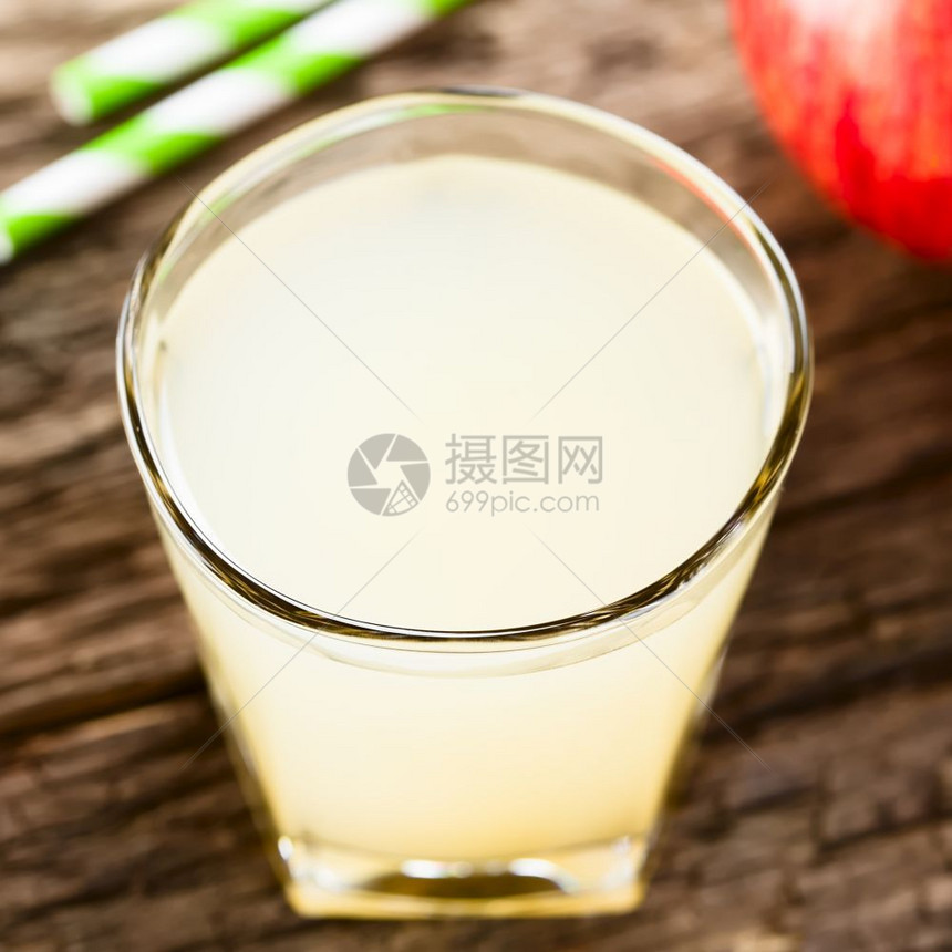 新鲜的用苹果和后背饮稻草在玻璃杯中刷新苹果汁拍摄在生锈的木制选择焦点上聚于玻璃圆面的苹果汁前部水重点图片