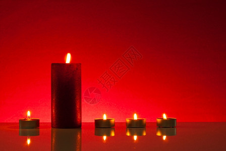 在红色背景的五支燃烧蜡烛光浪漫发图片