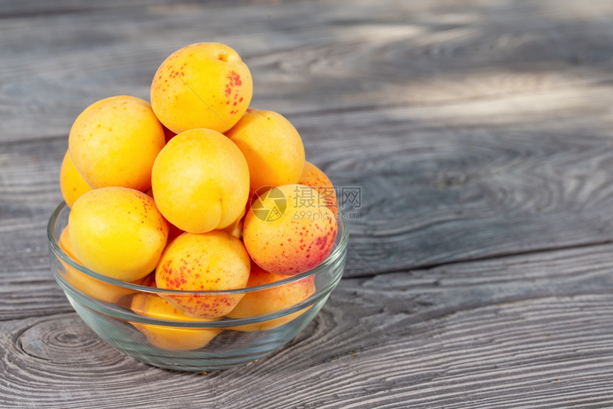 甜点木板上一个玻璃碗中的黄杏子木板上一个玻璃碗中的黄色杏子水果维他命图片