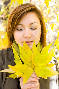 年轻女人看着秋叶图片