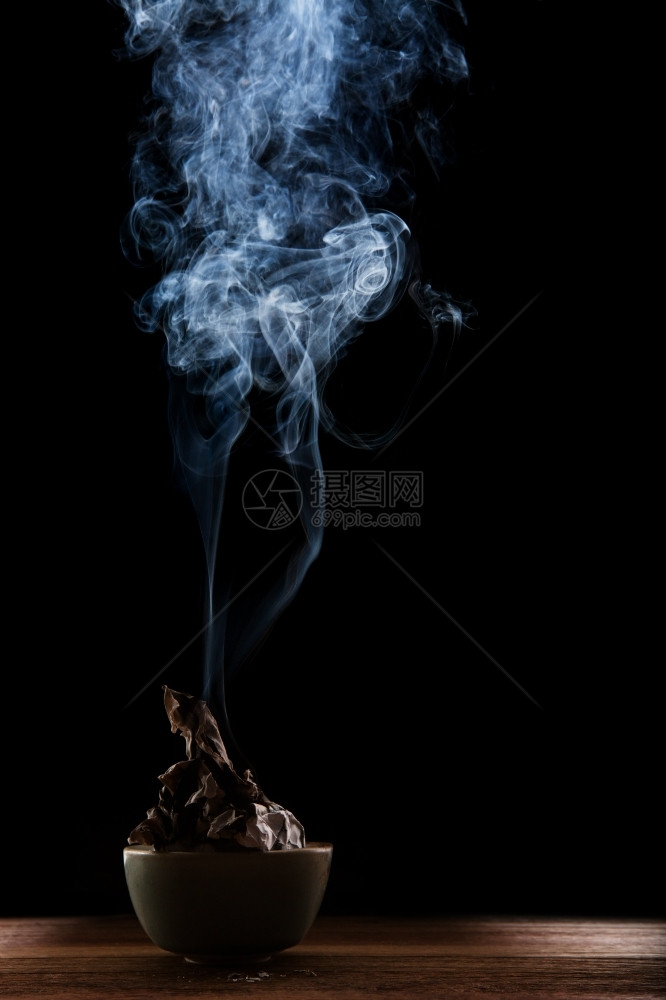 形式低的漆黑背景陶瓷弓中烧焦美丽烟雾和纸张照明抽烟图片