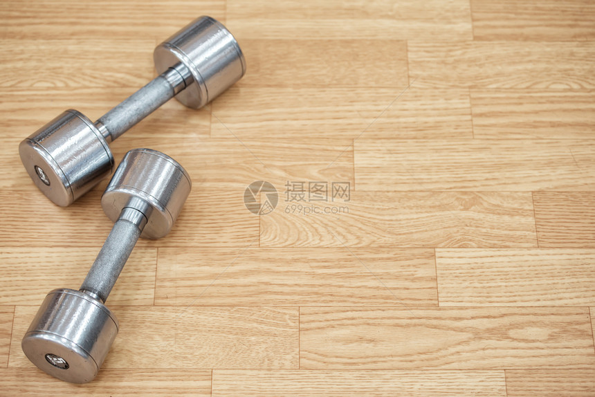 杠铃锻炼建造健身房地板上两个金属哑铃在地板上图片
