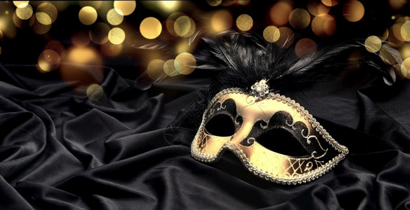 维什尼特配饰织物威尼斯黑布和模糊灯光背景上的美丽维尼特人狂欢节面罩背景