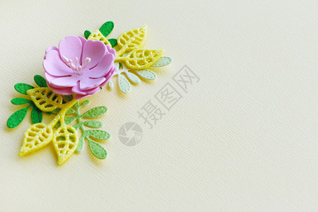 粉色的一种礼物浅黄纸背景上手工制作的黄绿不同形状人造粉红花叶图片