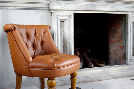 椅子壁炉前面的棕色皮手椅舒适自在图片
