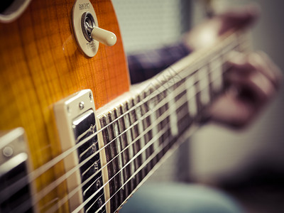 音乐玩细绳吉他手弹着电动时的选择焦点照片图片