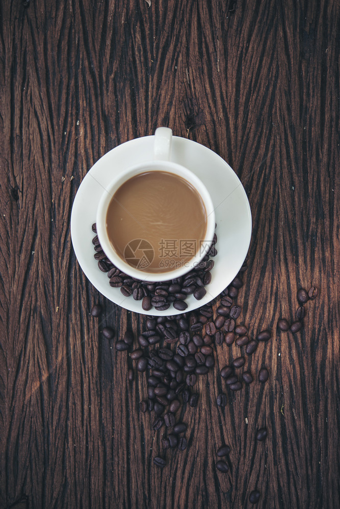 早餐咖啡因木制桌上杯和豆的顶端视图黑暗图片