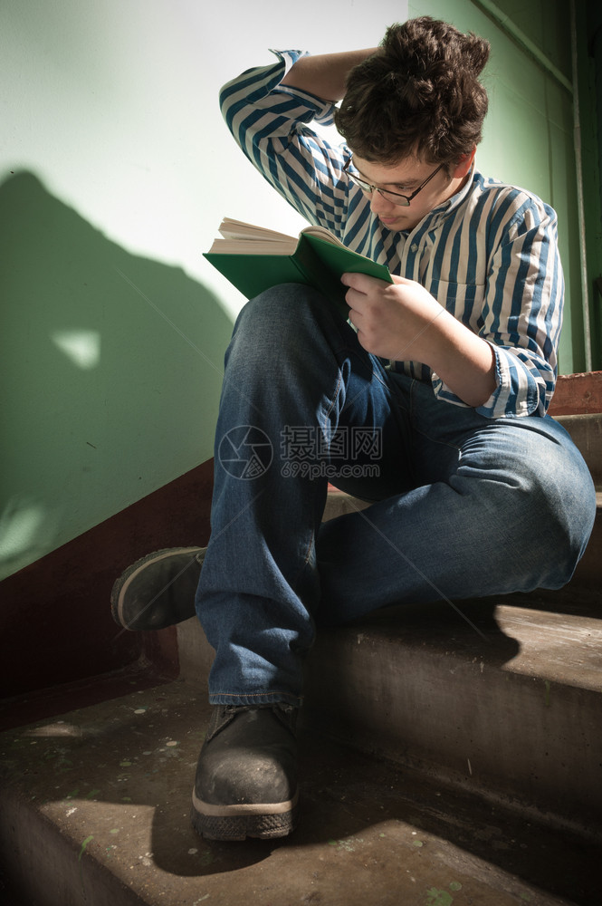 青少年读一本书坐在台阶上白色的图片