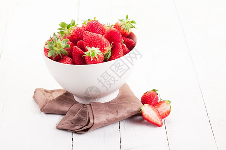 新鲜的食物水果白木桌的碗里有美味草莓图片