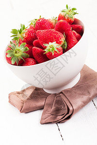 素食主义者白木桌的碗里有美味草莓乡村复制图片