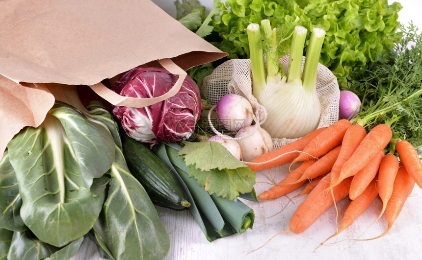维他命绿色可重复使用的蔬菜和纸袋中以及白桌上的其他新鲜蔬菜纸袋中的以及白桌上的其他新鲜蔬菜桌子图片