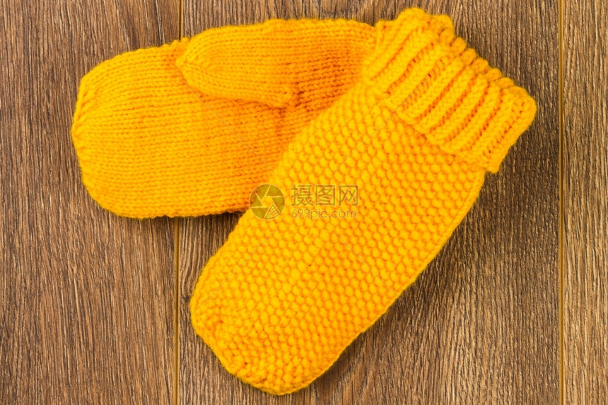 自制质地木背景上的黄色编织手套木材图片