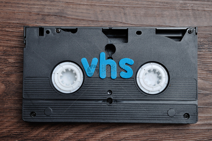 老的经典单词一张用VHS字在木制背景上隔离的录相带图片