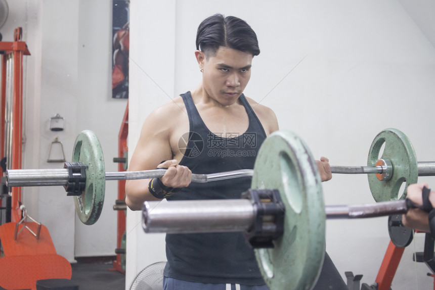 运动量来找到亚洲青年在镜子前举起巴铃的亚洲青年男子健身房图片