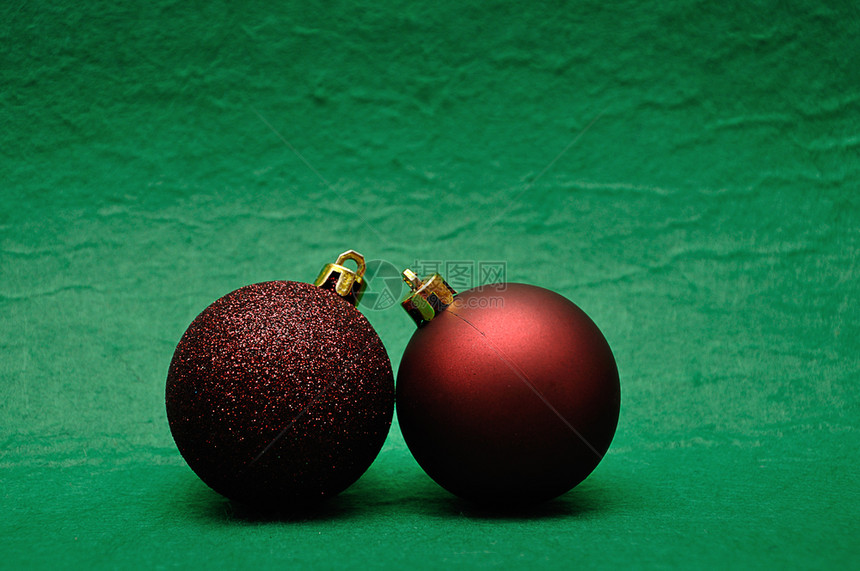 绿色背景上两棵红色圣诞球图片