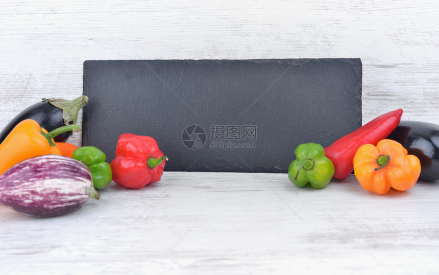 复制沟通黑板每边在白桌上涂满彩色的胡椒和茄子黑板两边在白桌上涂满彩色的蔬菜胡椒和茄子素食主义者图片