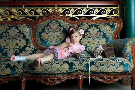 吻模式一个女孩在沙发上玩弄她母亲的首饰宝石图片