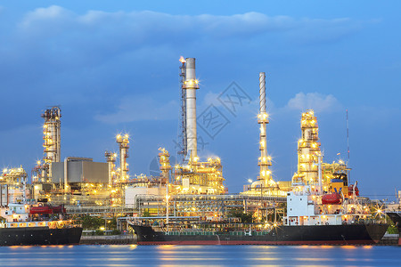 燃料灯光运输河流和船舶港口旁边的炼油厂图片