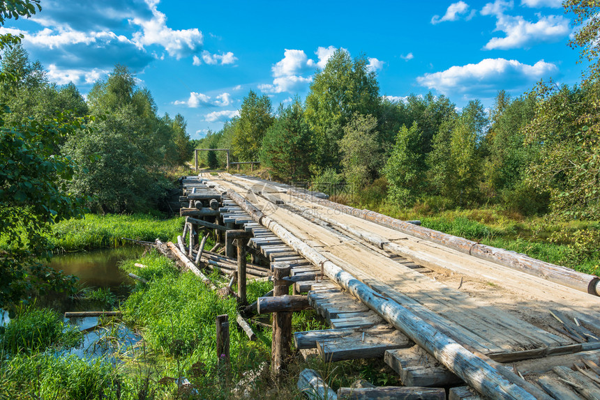 美丽在阳光明媚的夏日穿过一条小河的木桥自然绿色图片